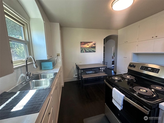 kitchen with sink, white cabinetry, and stainless steel range with electric stovetop