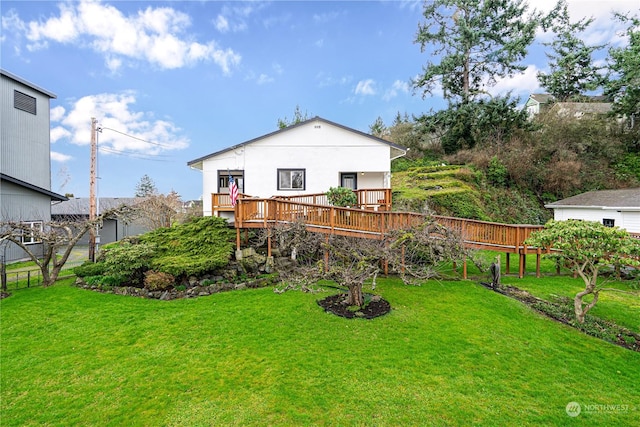 back of property with a lawn and a wooden deck