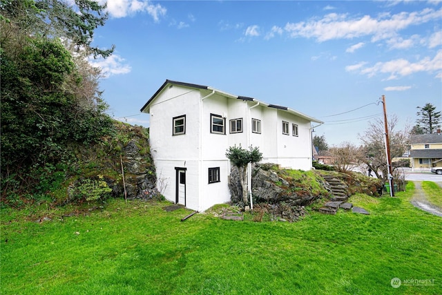 rear view of house featuring a lawn