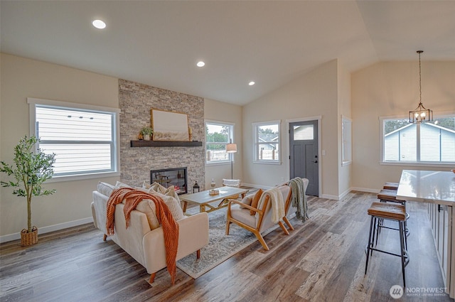 living area featuring lofted ceiling, dark wood-type flooring, a fireplace, and baseboards