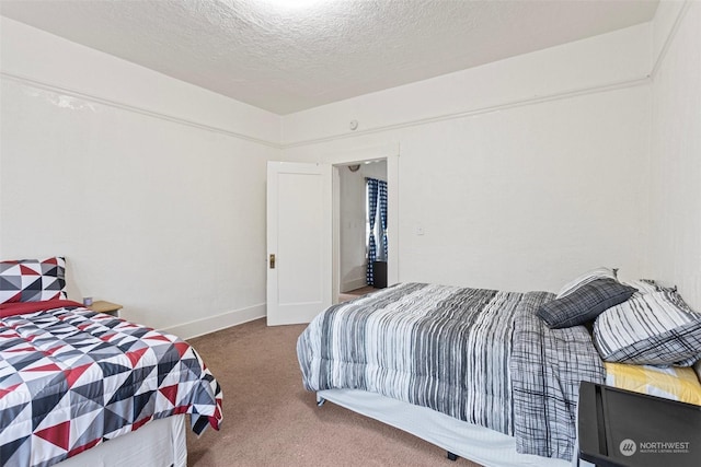 bedroom with dark carpet and a textured ceiling