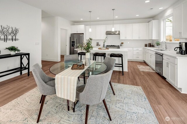 dining area with baseboards, recessed lighting, and light wood-style floors