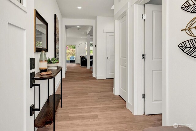 hallway with light wood-type flooring and recessed lighting