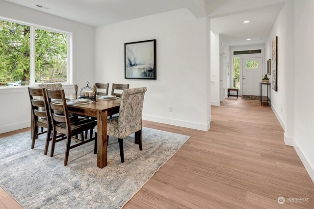 dining area featuring visible vents, plenty of natural light, light wood-style flooring, and baseboards