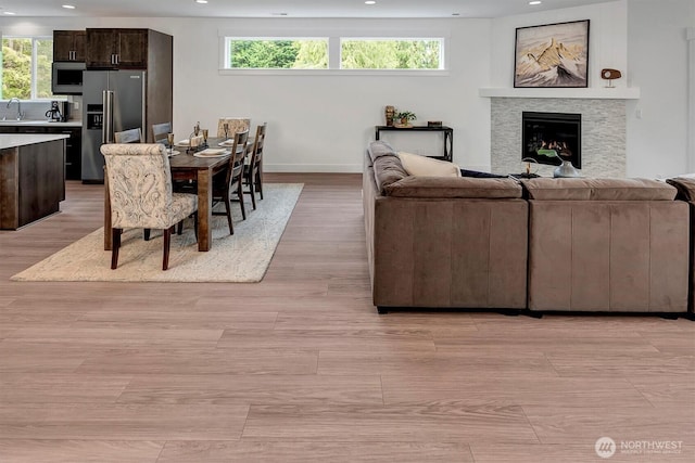 17018 106th Ave SE Unit 11, Renton, WA 98055 - living room with recessed lighting, healthy amount of natural light, baseboards, light wood-style flooring, and a warm lit fireplace