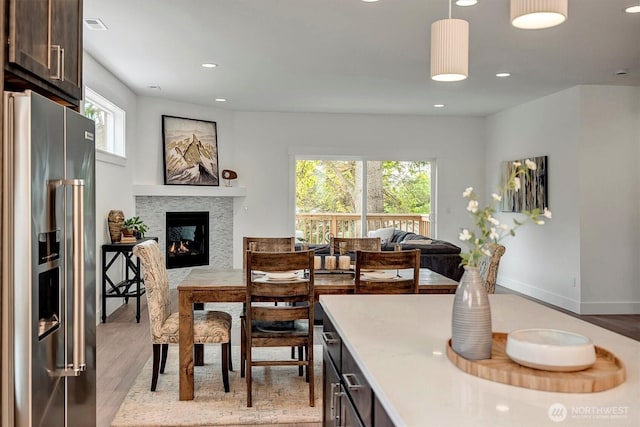 17018 106th Ave SE Unit 11, Renton, WA 98055 - dining space with light wood-style flooring, a multi sided fireplace, and recessed lighting