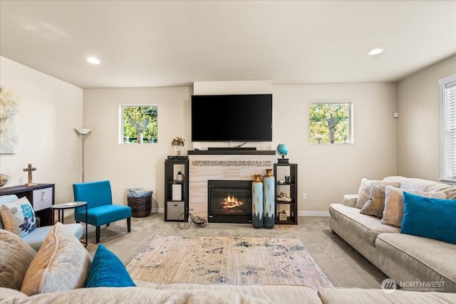 living room with light colored carpet, plenty of natural light, and a tiled fireplace