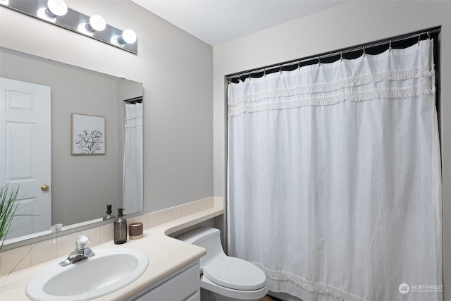 bathroom featuring curtained shower, toilet, and vanity