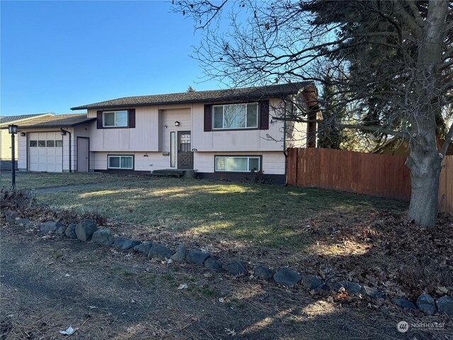 bi-level home featuring a garage and a front lawn