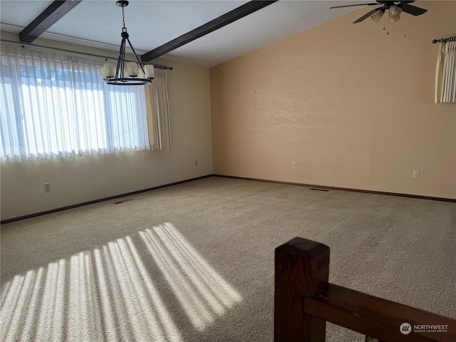 carpeted spare room featuring beamed ceiling and ceiling fan