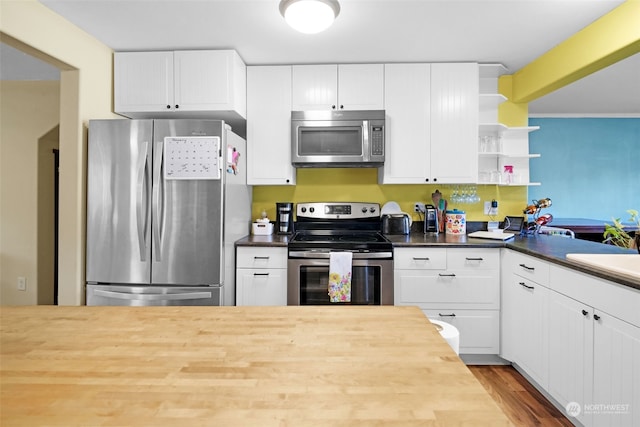 kitchen with white cabinets, stainless steel appliances, light hardwood / wood-style flooring, and wood counters