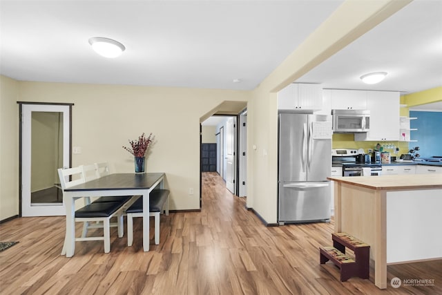 kitchen featuring light wood-type flooring, white cabinetry, and stainless steel appliances