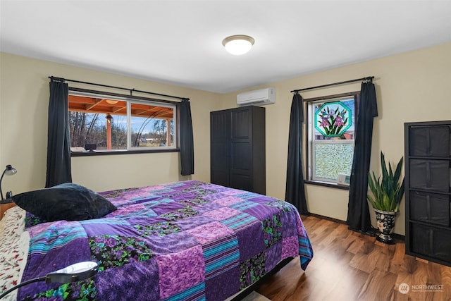 bedroom featuring a wall mounted air conditioner and wood-type flooring