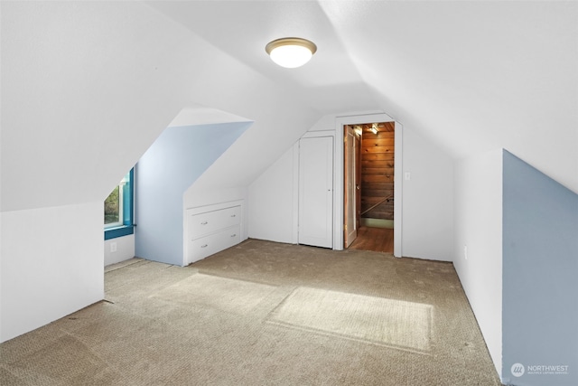 additional living space with vaulted ceiling and light colored carpet