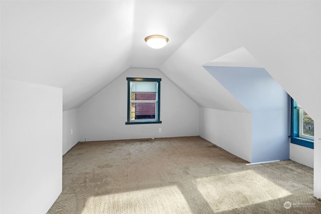 bonus room featuring light carpet and vaulted ceiling