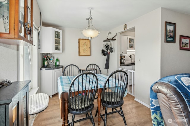 dining area featuring sink and light hardwood / wood-style flooring