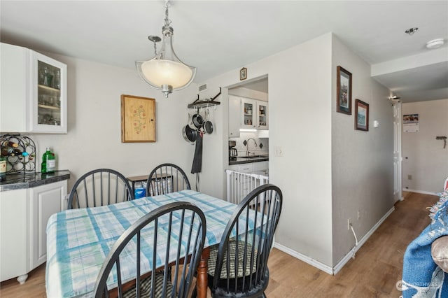 dining area featuring sink and light wood-type flooring