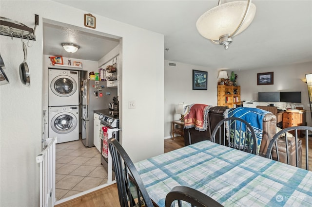 dining room with stacked washing maching and dryer and light tile patterned floors