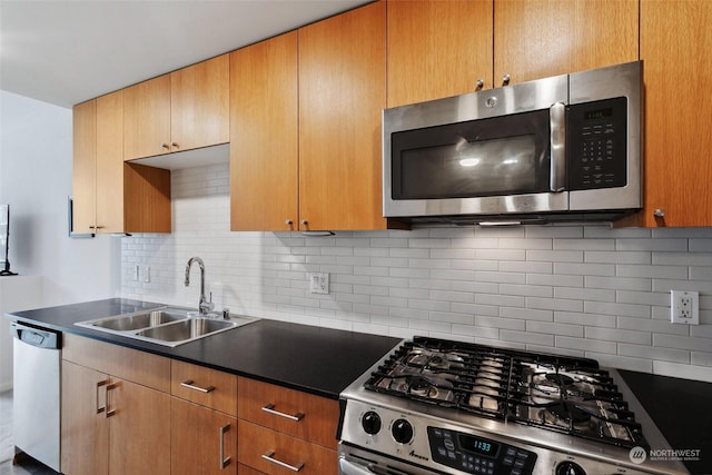 kitchen with appliances with stainless steel finishes, sink, and decorative backsplash