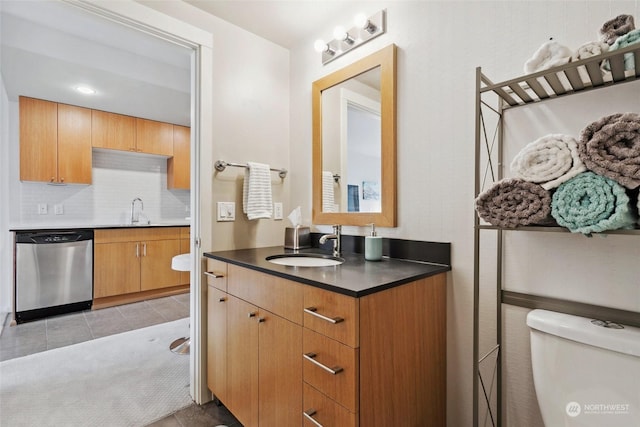 bathroom featuring tile patterned flooring, vanity, backsplash, and toilet