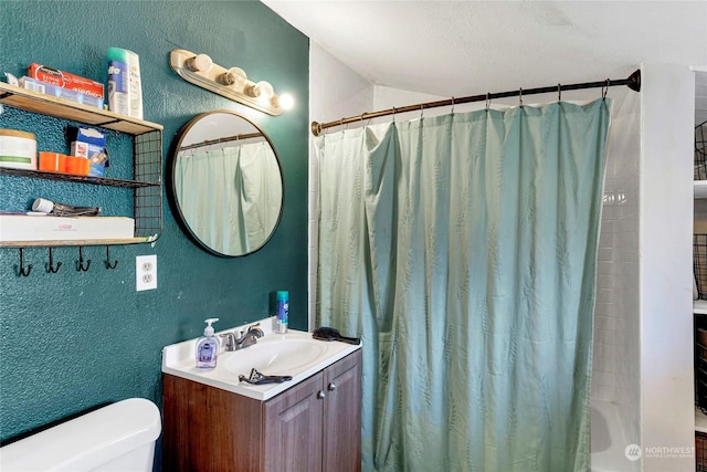 full bathroom featuring vanity, toilet, a textured ceiling, and shower / bath combo