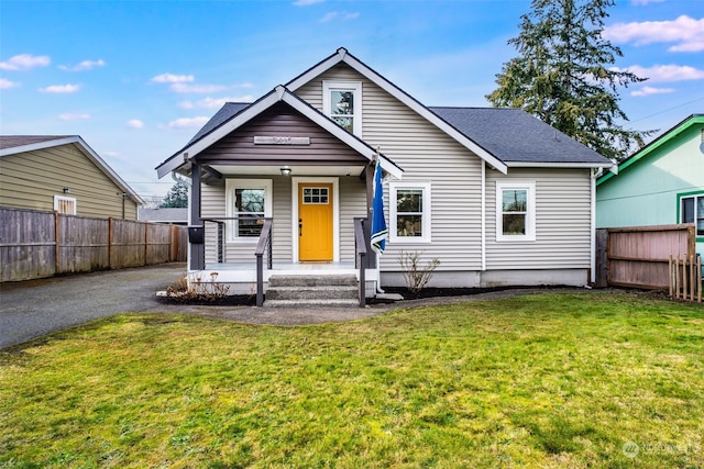 bungalow-style house featuring covered porch and a front yard