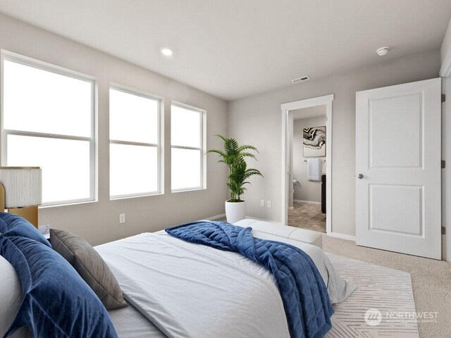 bedroom with ensuite bathroom and carpet