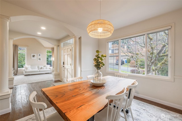 dining space featuring hardwood / wood-style flooring and decorative columns