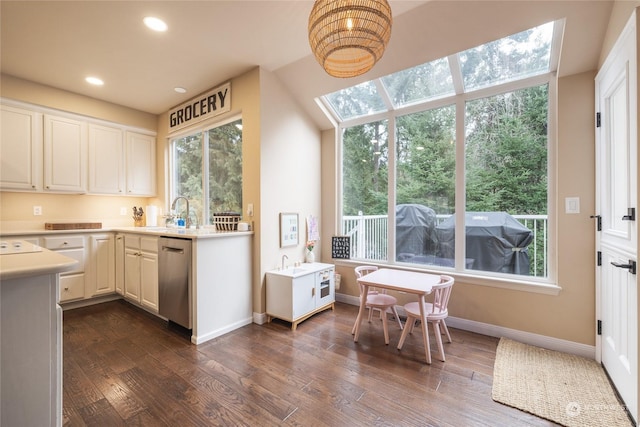 kitchen with sink, dark wood-type flooring, stainless steel dishwasher, and white cabinets