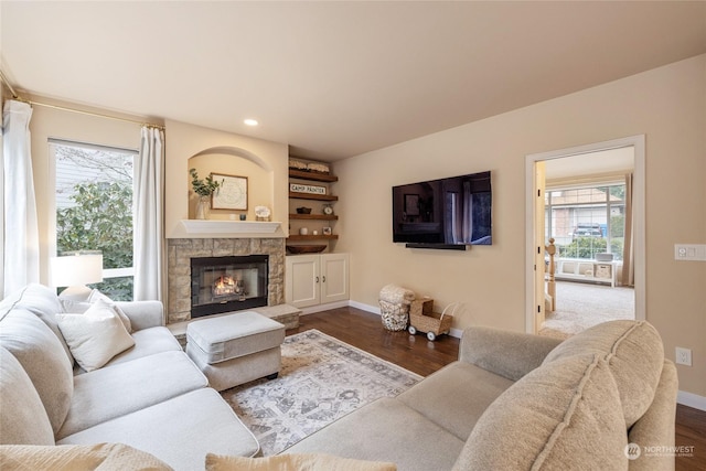 living room featuring dark wood-type flooring and a fireplace