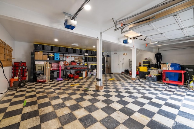 garage with a garage door opener and stainless steel refrigerator with ice dispenser