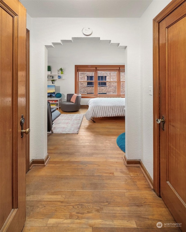 hallway with light hardwood / wood-style floors