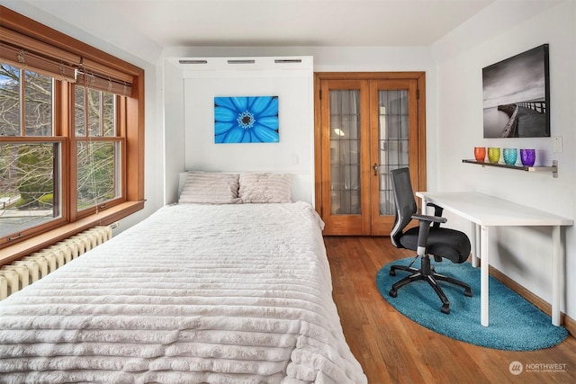 bedroom with hardwood / wood-style flooring and radiator