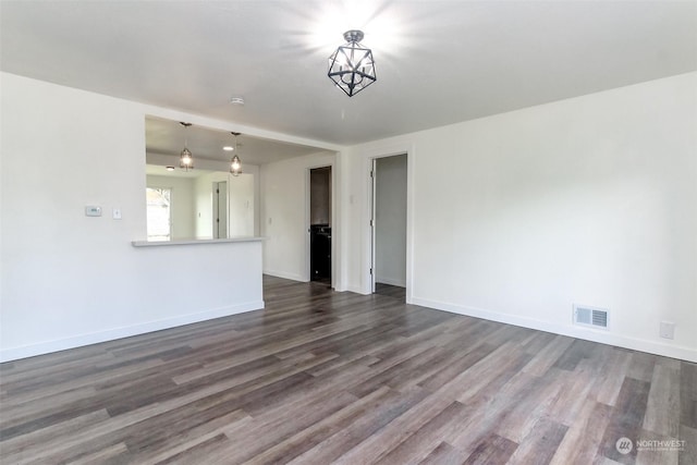 unfurnished living room with hardwood / wood-style floors and a notable chandelier