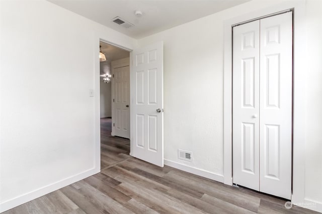 unfurnished bedroom with a closet and light wood-type flooring