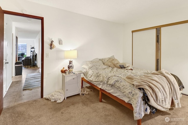 bedroom with a closet and light carpet