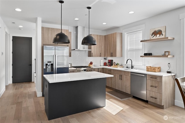 kitchen featuring decorative light fixtures, tasteful backsplash, a center island, stainless steel appliances, and wall chimney exhaust hood