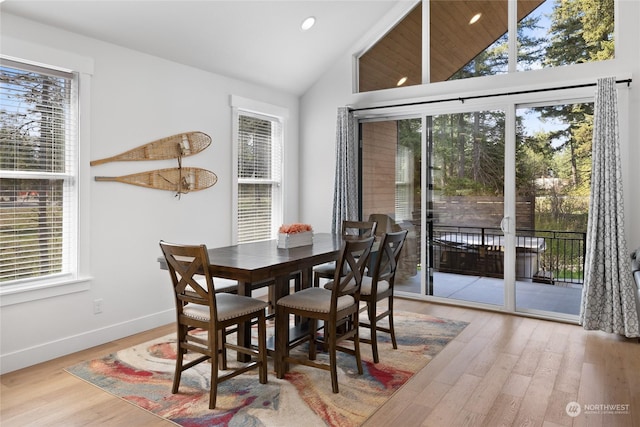 dining area with plenty of natural light, light hardwood / wood-style floors, and vaulted ceiling