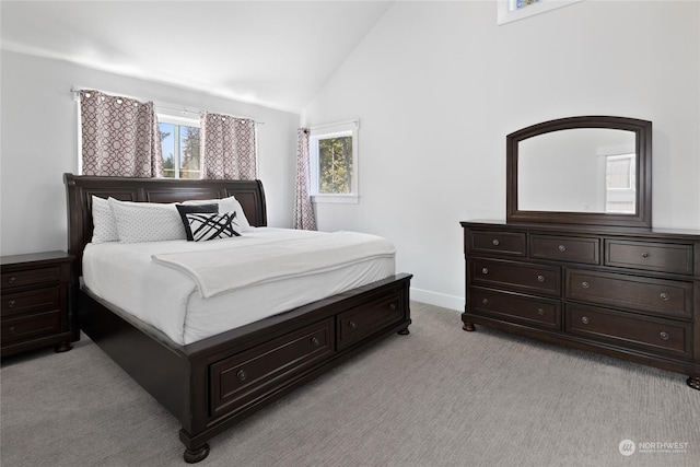 bedroom with vaulted ceiling and light carpet