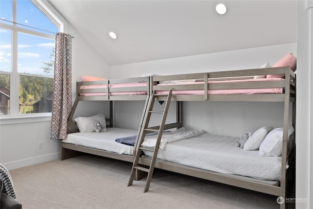 carpeted bedroom featuring lofted ceiling and multiple windows