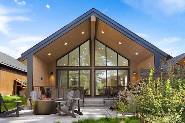 back of property featuring a patio and an outdoor fire pit