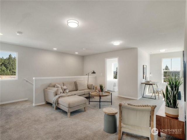 living room featuring light colored carpet and a healthy amount of sunlight