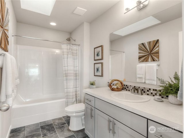 full bathroom with toilet, shower / bath combination with curtain, a skylight, and vanity