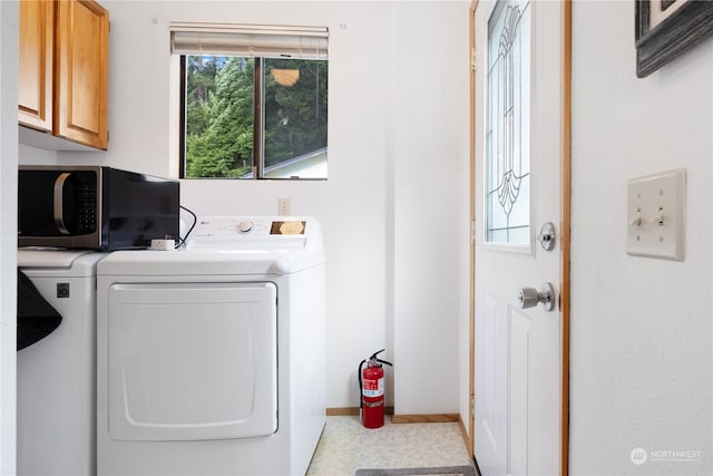 clothes washing area featuring cabinets and independent washer and dryer