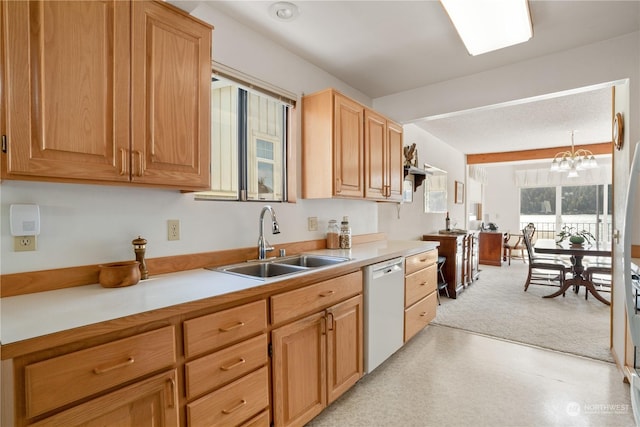 kitchen with sink, hanging light fixtures, dishwasher, and a notable chandelier