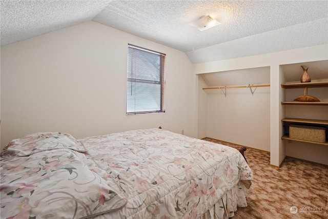 carpeted bedroom featuring a closet, a textured ceiling, and lofted ceiling