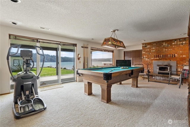 game room featuring carpet, pool table, a textured ceiling, and a wood stove