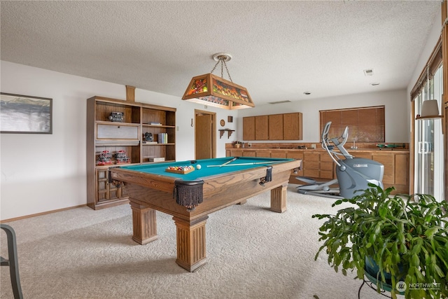 rec room with light colored carpet, a textured ceiling, and pool table