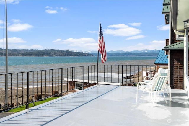 balcony featuring a beach view and a water and mountain view