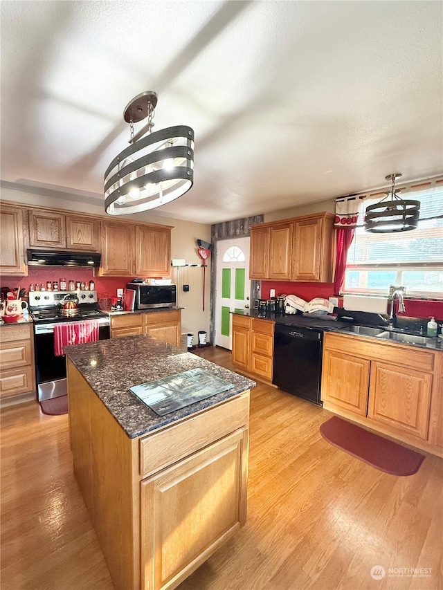 kitchen featuring pendant lighting, sink, a center island, light hardwood / wood-style floors, and stainless steel appliances